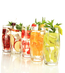 Glasses of fruit drinks with ice cubes isolated on white