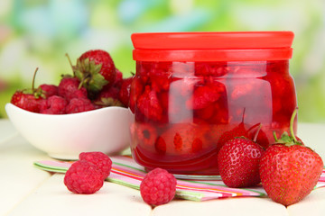 Home made berry jam on wooden table on bright background