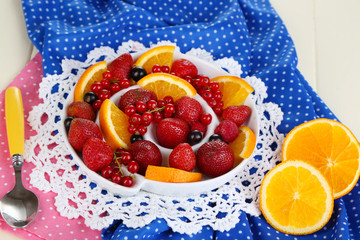 Useful fruit salad in plate on wooden table close-up