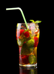 Iced tea with raspberries and mint on black background