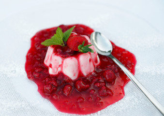 Creamy panna cotta served with raspberry sauce