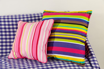 Colorful pillows on couch isolated on white