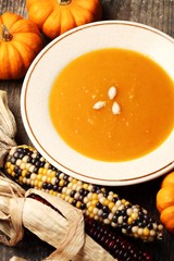 Pumpkin soup and autumn fruits on a table