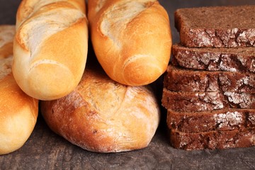 Rye bread and baguettes on wooden background