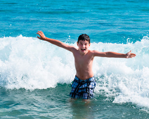 Bambino che gioca tra le onde