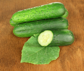 Tasty green cucumbers on wooden background