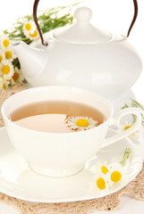 Cup of herbal tea with camomiles close up