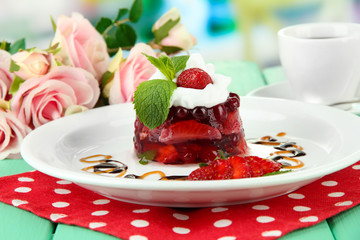 Tasty jelly dessert with fresh berries, on bright background