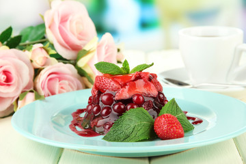 Tasty jelly dessert with fresh berries, on bright background