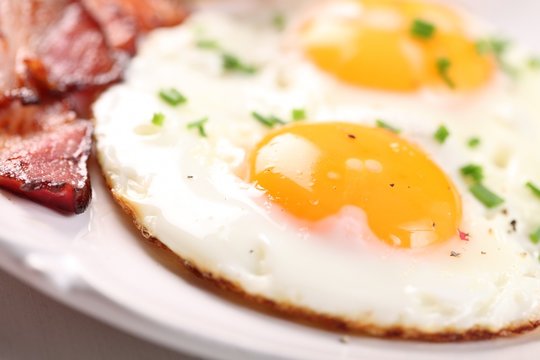 Close-up of fried egg and bacon on plate