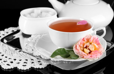 Obraz na płótnie Canvas Kettle and cup of tea from tea rose