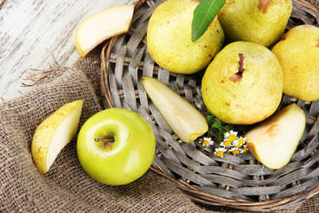 Pears on braided tray on burlap  on wooden table