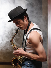 Fototapeta na wymiar Improvising with his saxophone. Handsome young jazzmen playing s