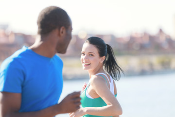 Friends meeting. Young couple smiling to each other while joggin