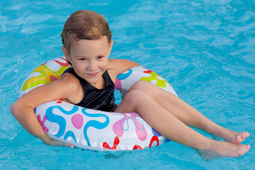 little girl in the pool  with rubber ring