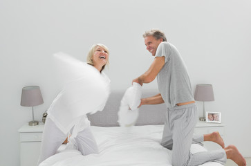 Fun couple having a pillow fight