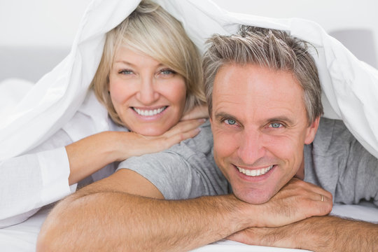 Couple smiling under the covers