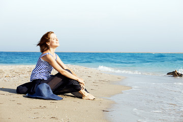 Fototapeta na wymiar beautiful tanned woman resting on the beach in summer day