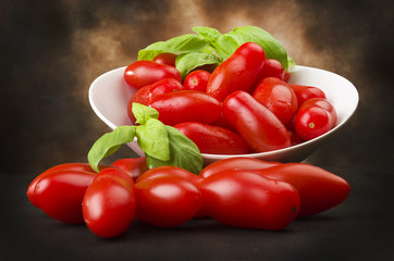 Tomatoes and basil close up on the wood