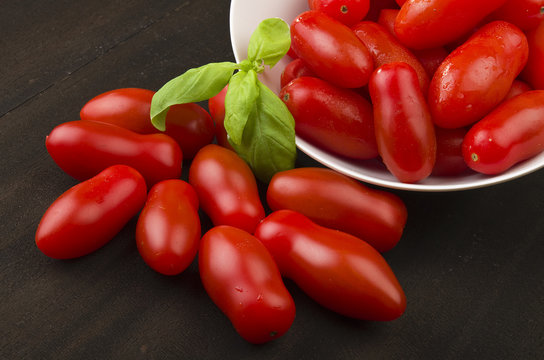 Tomatoes and basil close up on the wood
