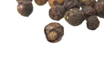 Beans of black pepper close up on white