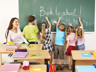 Children writing on blackboard.