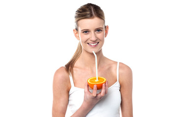 Girl sipping orange juice through straw