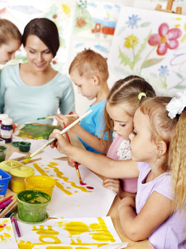 Children with teacher painting.
