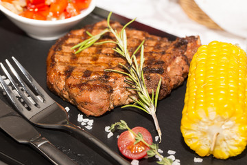 Grilled steak with sauce and greens