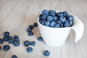 White bowl cup with fresh ripe blueberries