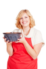 young blond woman with bundt cake and red apron