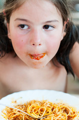 Cute little girl enjoying pasta sauce