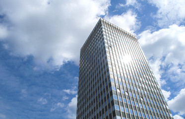 Obraz na płótnie Canvas One Isolated Skyscraper with Blue Sky and Clouds