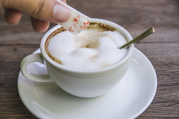 pouring sugar into a coffee