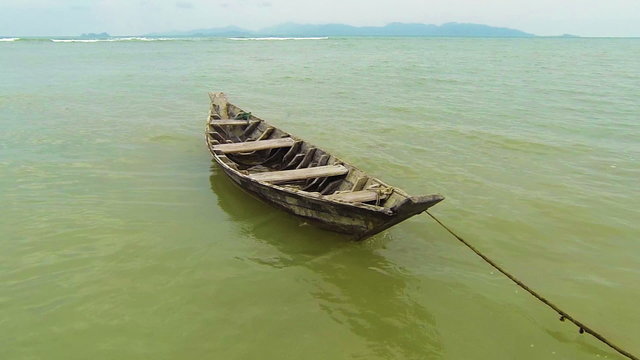 Old wooden simple fisherman boat at the shore