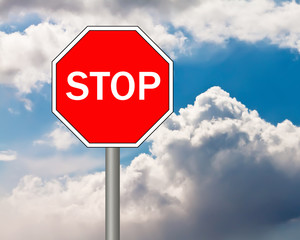 Stop sign on blue cloudy sky background.