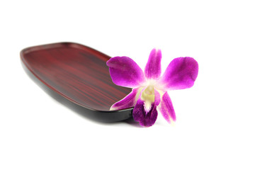 Purple orchid on a wooden plate.