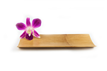 Purple orchid in bamboo dish.