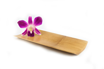 Purple orchid in bamboo dish.