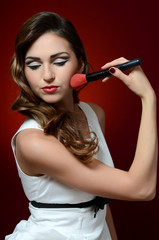 Fototapeta premium The beautiful girl with brushes make-up