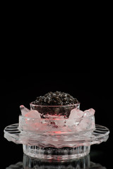Black caviar on a black isolated and blank
