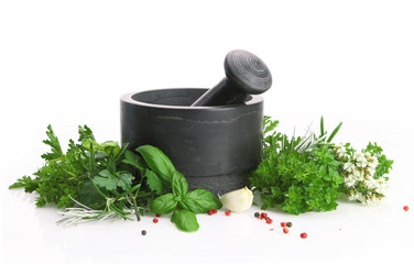Black stone mortar and pestle with fresh herbs