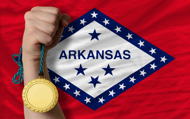 Fototapeta na wymiar Złoty medal dla sportu i flaga amerykański stan Arkansas