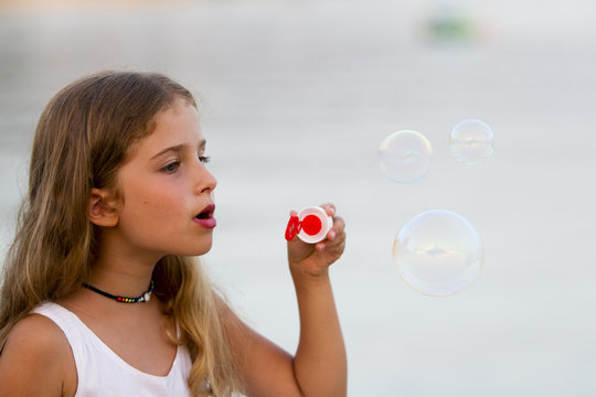 Soap bubbles - lovely girl blowing bubbles