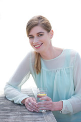Young woman smiling and enjoying a fresh drink 
