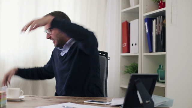 Angry businessman destroying laptop in the office