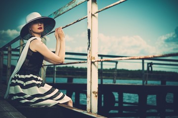 Stylish beautiful  woman on an old pier