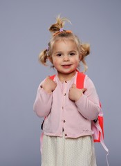 Funny little school girl with a backpack 