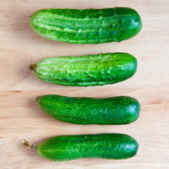 four green cucumber on the board