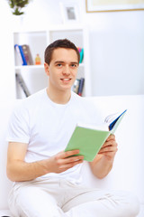 Young man at home with a book